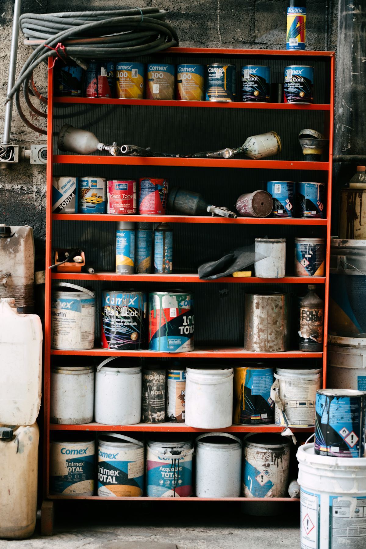 Rek vol potten verf en blikken in een winkel